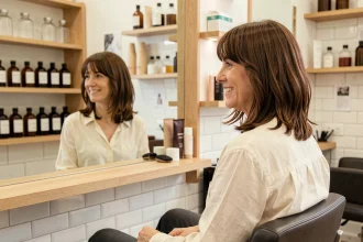Femme de 40 ans avec une coupe en dégradé et une frange rideau rajeunissante dans un salon de coiffure parisien